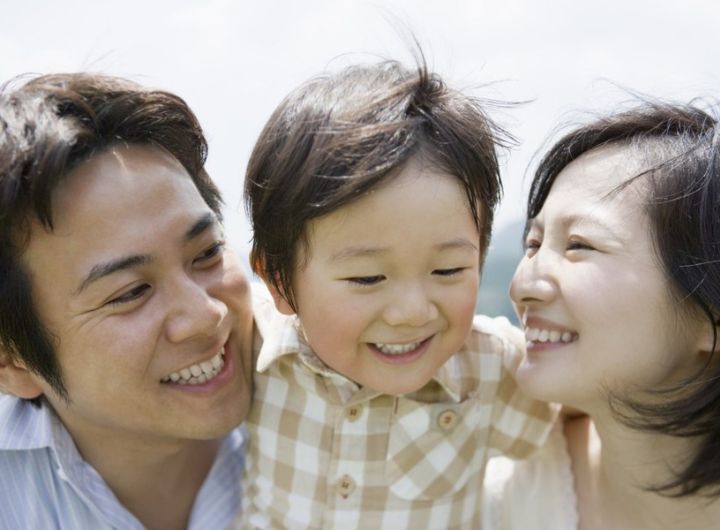 happy parents either side of toddler-age boy